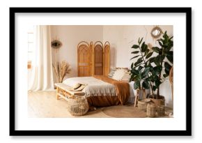Modern home interior design. White and beige blankets on comfortable bed in boho bedroom interior Textured walls, wooden floor, sunny shades, natural materials, straw screen