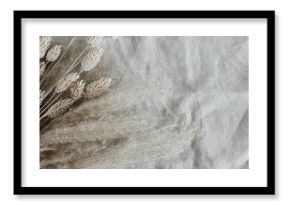 Dry beige grass plant bouquet top view on beige linen fabric texture banner.Flowers background . Copy space.