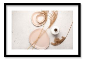 Dry common reeds and dishes on white background