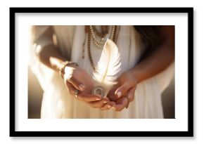 Woman with boho jewellery holding a feather in her hands close up