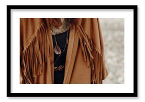 stylish hipster boho traveler woman look. gypsy girl in fringe jacket with feather bronze accessory. wanderlust summer travel. atmospheric moment. space for text.