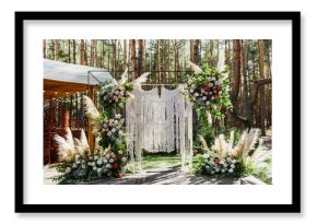 Beautiful wedding ceremony with an arch in boho style in the forest.