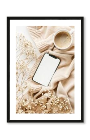 Elegant home office desk table with beige blanket, smartphone with blank screen mockup, cup of coffee, dry flowers on white background. Boho style or hygge feminine workspace. Flat lay, top view.