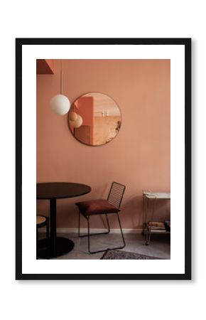 Aesthetic modern Scandinavian home interior design. Elegant bohemian living room with coral walls, comfortable lounge chair, carpet, coral color walls, mirror, table, decorations