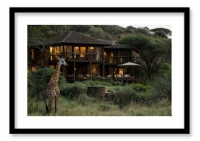 A giraffe standing near a cozy lodge at twilight in the savannah.