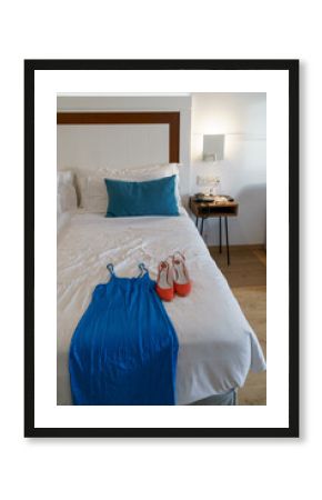 Vestido de fiesta azul y tacones rojos encima de la cama de un hotel de lujo 