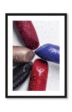 Five lipsticks different colors on the white background. Water drops on lipstick and background
