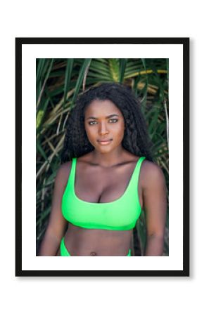 African woman in swimsuit lookin at camera