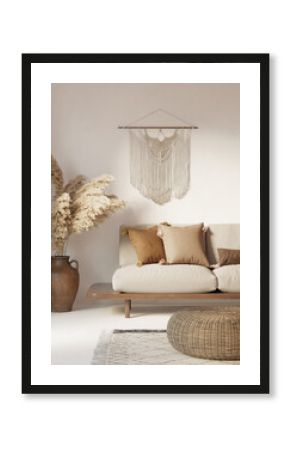 3d white and beige bohemian interior with boho macrame wall hanging decor, pampas grass, a round wicker coffee table and a sofa with cushions with pom pons