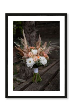 Beautiful wedding bouquet in vintage style. Boho bridal bouquet composed of lisianthus, pampas grass, roses and dried flowers. Wedding day.