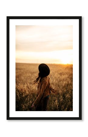 Boho nomads girl in field at Sunset