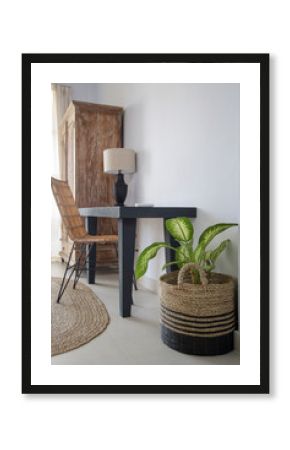 Wooden work desk and modern rattan chairs in beachy boho chic bedroom. Eco friendly furniture in neutral tones.