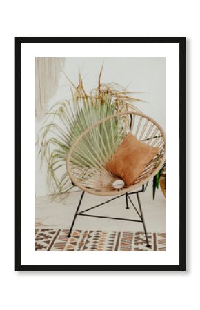 chair on the table with flowers. interior in Bali style. Wooden wicker chair. Boho style summer interior