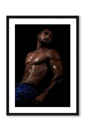 El cuerpo masculino perfecto - Impresionante culturista posando. Chico joven musculado. Aislado sobre fondo negro. Espacio para texto