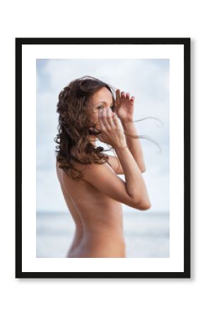 naked woman posing on the sea beach