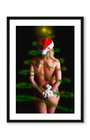 Mujer de espaldas desnuda con pino navideño simulado y osito de peluche