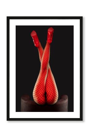 A sexy girl in black mesh tights and red patent leather high-heeled shoes is dancing in a dark room.