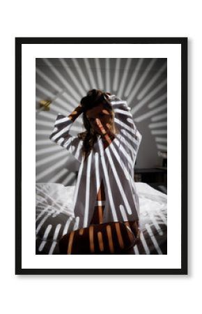 Slender girl in lingerie with shadows on her body