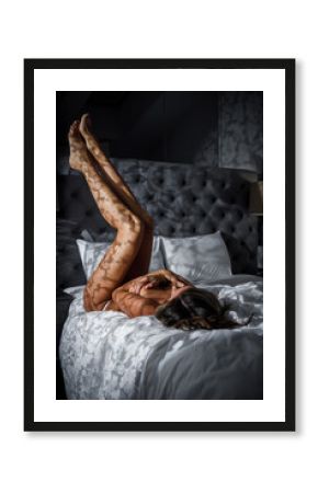 Slender girl in lingerie with shadows on her body