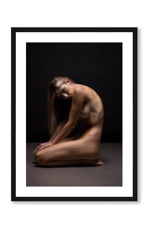 Athletic natural woman body on dark background. Nude woman Yoga. 