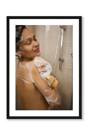 Attractive sexy woman smiles and enjoys a foam shower, in a douche cabin in her bathroom. Home spa, beauty, nudity, relaxation, skin, body and hair care. Morning daily routine. Purity and hygiene