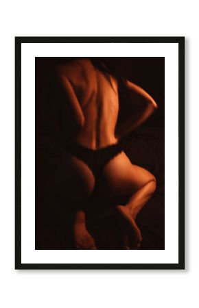 Back sexy girl woman with sexy ass in panties posing on bed in bedroom at night. Motion blur