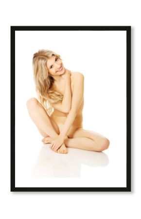 Nude woman sitting cross-legged on the floor