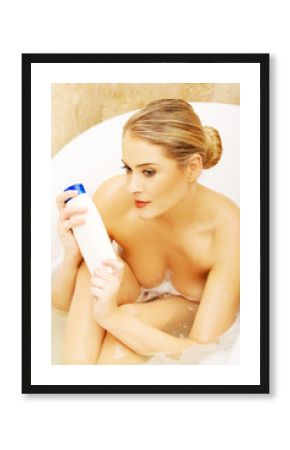 Beautiful woman holding shampoo sitting in a bath