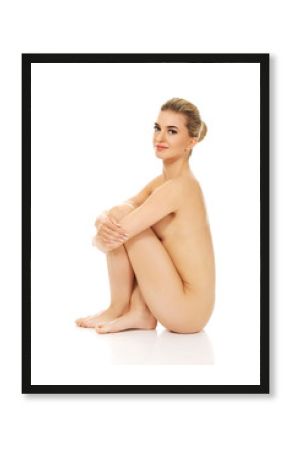 Young naked woman sitting on the floor