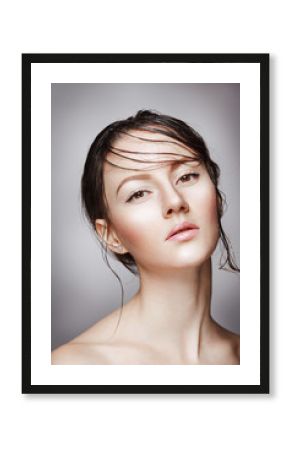 Portrait of young beautiful nude woman with wet shining  makeup on grey background