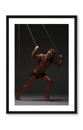 Young naked man, muscular body, bounded with rope