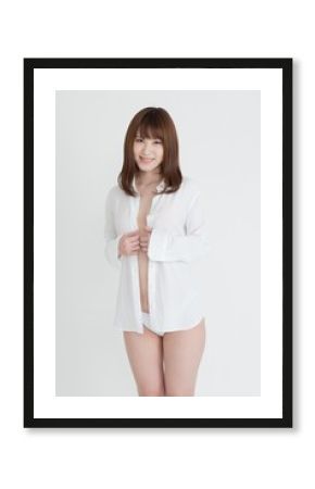 白いシャツを着たセクシーな女性。この女性は、脚の素肌を見せています。スタジオ撮影。白背景。