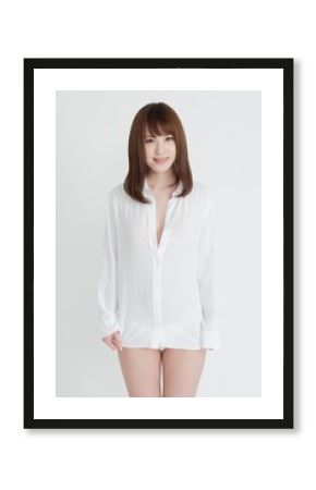 白いシャツを着たセクシーな女性。この女性は、脚の素肌を見せています。スタジオ撮影。白背景。