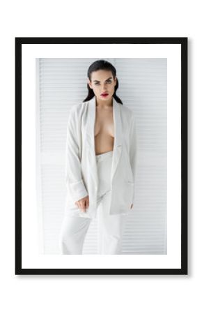 seductive half naked woman posing in white fashionable suit