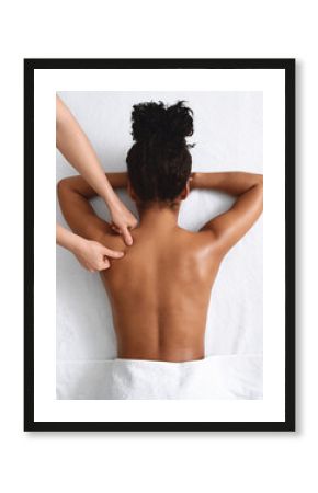 African american naked woman getting relaxing back massage on white