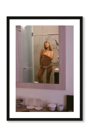 Passionate sexy young naked woman takes a shower and covers herself with a towel