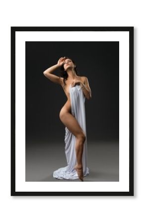 Graceful naked woman wrapped in white cloth