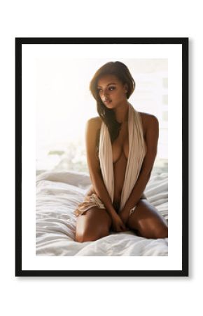 Introspective beauty. Full length shot of a sexy young woman looking thoughtful while sitting nude on her bed at home.