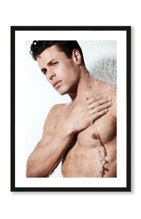 Dripping with masculinity. Cropped shot of a muscular young man under the running water of a shower.