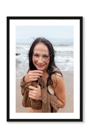 Wet halfnaked woman on a cold day at the seashore