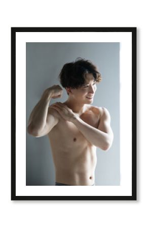 筋肉を鍛えるカッコイイハンサムな日本人男性　上腕二頭筋　美しい逆光のイメージの縦
