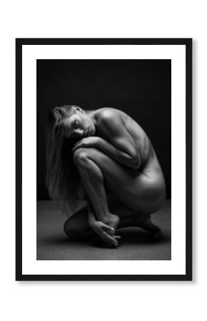 Abstract fine-art portrait. Black and white photo of nude beautiful woman. Female body on black background. 