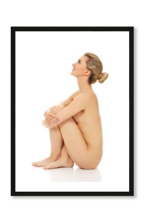 Young naked woman sitting on the floor