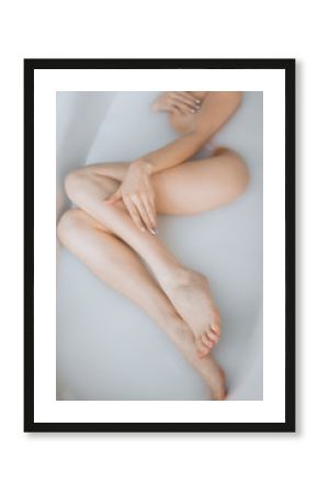 Closeup on legs of european young woman in milky bathtub