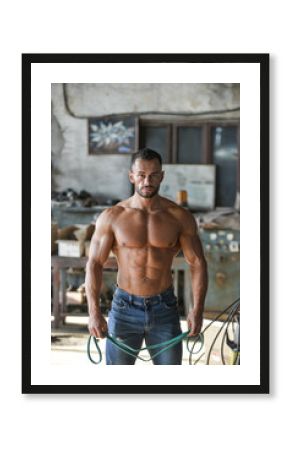 Muscled half naked man at work in an old factory.