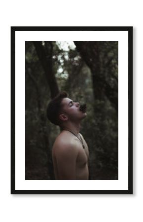 Hombre en el bosque con piña en la boca