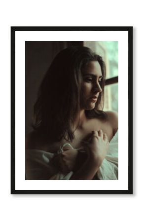 mujer en interior al lado de una ventana