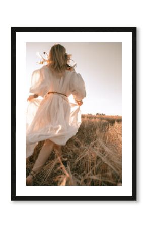  girl runs with bare feet across a wheat field in a white dress boho style