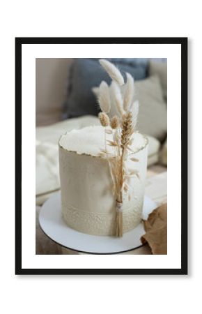 Amazing minimalistic cake cream beige decorated by dry ear of wheat cotton in boho scandi style