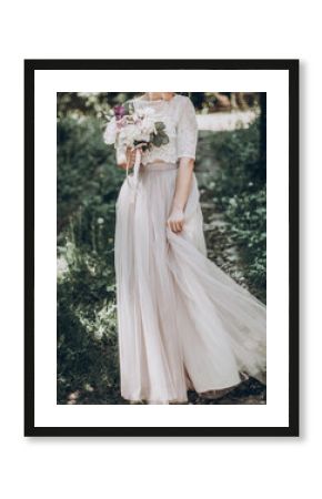 stylish wedding bride with bouquet and amazing modern dress. bride posing and smiling in sunny garden, dancing. fine art wedding photo, romantic moment